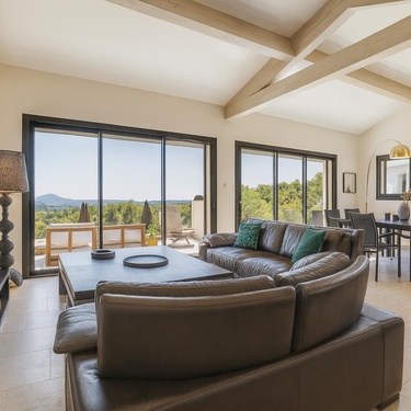 Magnifique salon lumineux avec vue panoramique, doté de canapés en cuir confortables, de grandes baies vitrées et d'une décoration contemporaine sous une belle charpente apparente.